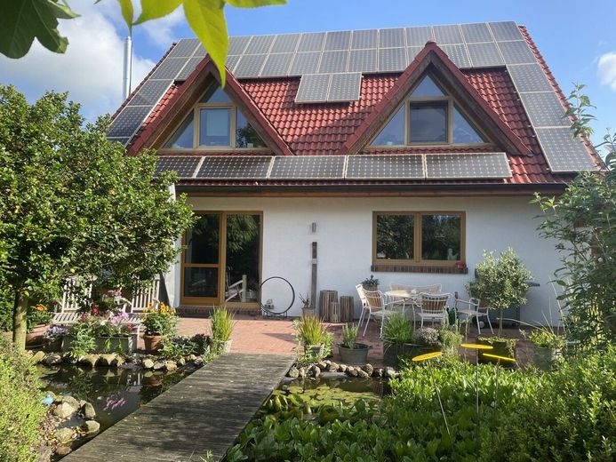 Exquisites Einfamilienhaus in neuwertigem Zustand mit PV-Anlage,Carport und idyllischer Gartenanlage – Gartenansicht mit PV-Anlage