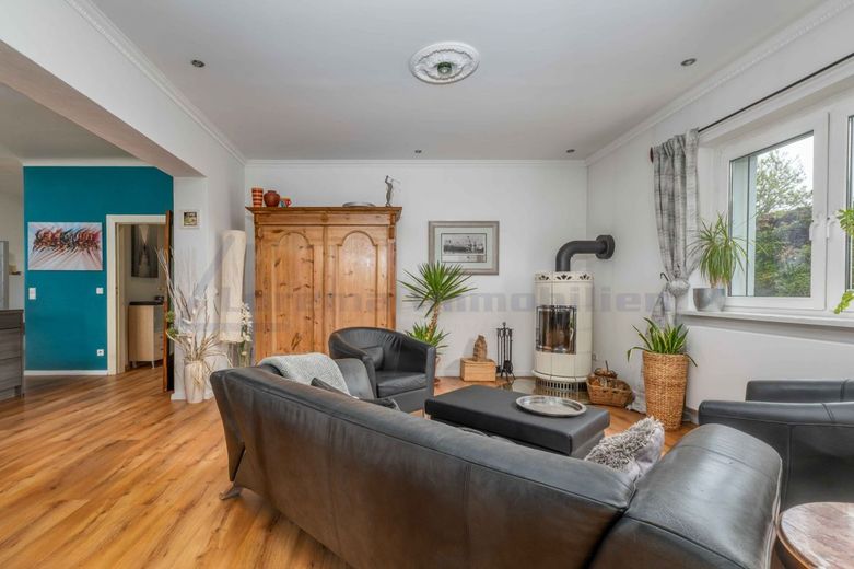 Grüne Oase südlich von Berlin - großes EFH in Mahlow mit 1.192 m² und Energieklasse A – gemütliches Wohnzimmer mit Kamin