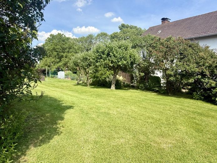 Viel Raum für Ideen: Zweifamilienhaus mit großem Garten, Garagen und Nebengebäude in Gohfeld – Sonniger Garten