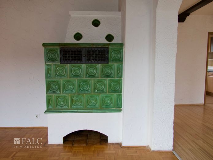 Einfach Mehr: Bungalow mit ELW. Garage, Süd-Loggia-Terrasse. Wohnreserve. Ruhige Wohnlage. Frei. – EG: Kachelofen Wohnzimmer