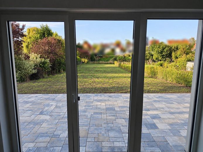 2026’da ilk kez oturuma hazır: Magdeburg’un güneyinde ikiz evin yarısı – bahçe, şömine, ısı pompası, 150 m², A+ – Wohnbereich mit Terrassentür