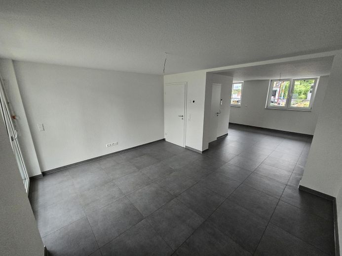 Moderno appartamento di 2,5 locali al piano terra, conforme allo standard KfW-55-EE – efficiente dal punto di vista energetico e dotato di finiture di pregio – Wohnzimmer