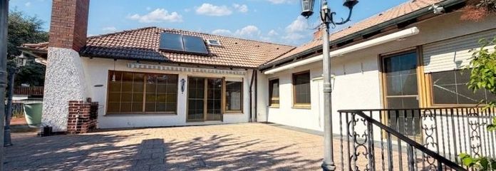 Bungalow nécessitant des travaux de rénovation, entièrement sous-solé, avec terrain ressemblant à un parc et garage double.