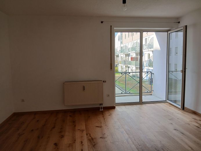 Affascinante bilocale con balcone e posto auto in autorimessa interrata — Regensburg-Galgenberg – Wohnzimmer zum Westbalkon