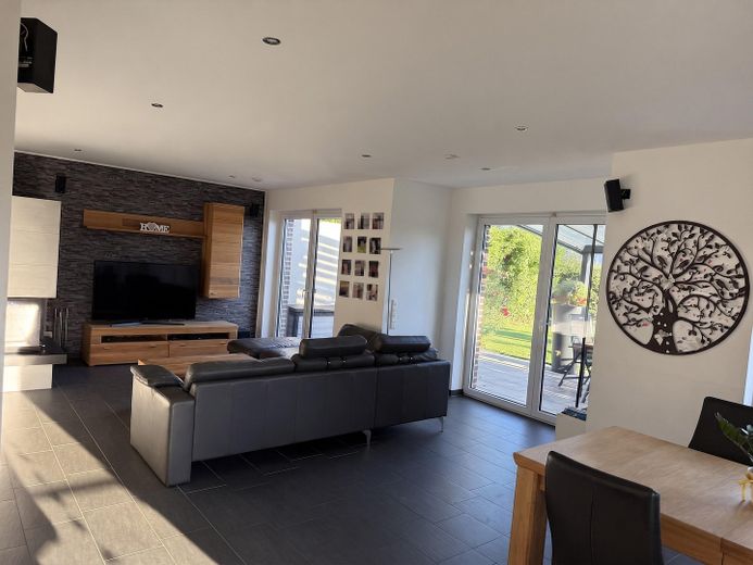 Modernes Massivhaus in ruhiger Neubausiedlung: Südausrichtung, Terrassendach, Sauna & 9m-Garage – Wohnzimmer