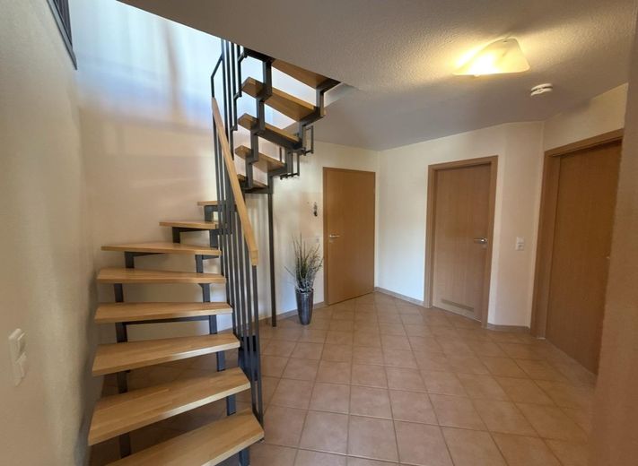 Jasny 3-pokojowy apartament dwupoziomowy (79 m²) z balkonem od południa, 2 łazienkami, wbudowaną kuchnią i miejscem w garażu podziemnym w Nufringen – Flur