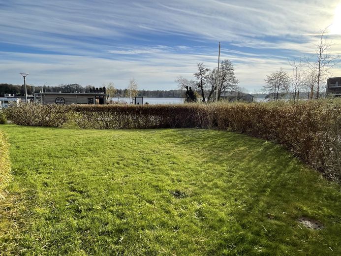 Sonnige Wohnung direkt am See in Neuruppin mit Gartenterrasse, voll ausgestattet – 17_Wiese vor Terrasse