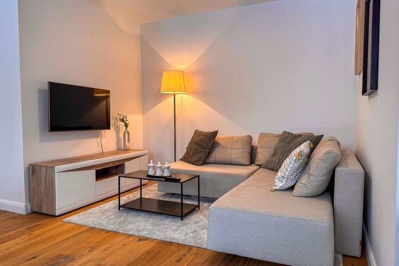 Wohnen wie im Haus: Ebenerdig 3 Zimmer mit Garten u. Tiefgarage am Bürgerpark im Neubau von 2023 – Wohnzimmer