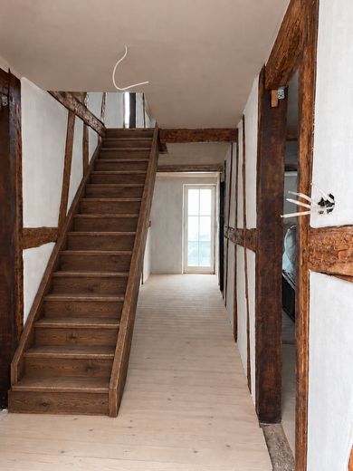 Tarihi ahşap karkas, modern yaşam konforuyla buluşuyor – kendine özgü cazibesiyle kapsamlı yenilenmiş sıra ev – Flur mit Treppe in Obergeschoß