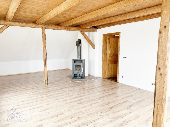 ***VIEL PLATZ &amp; BESONDERER WOHNCHARAKTER - 6-ZIMMER-MAISONETTE MIT KAMIN*** ab demnächst zu vermieten – Wohnzimmer mit Kaminofen &amp; Holzbalkendecke, Blick Richtung Flurbereich - untere Wohnebene