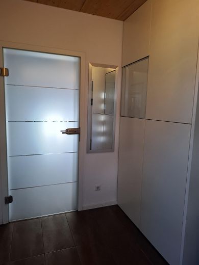 Energy-efficient passive house in a quiet location – Vorsaal,Glastür zum Wohnzimmer