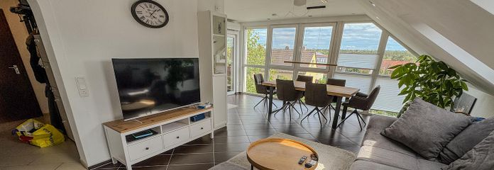 Traumhafte 4-Zimmer-Dachgeschosswohnung mit Panoramablick, Klimaanlage & Carport – Wohnzimmer mit Fensterfront