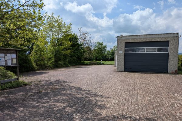 Bedrijfsterrein (splitsing mogelijk) met grote garages en woonmogelijkheid aan de rand van het veld
