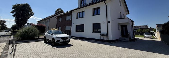 Premium 3-Zimmer-Maisonette-Wohnung mit offener Wohn-Ess-Küche, Dachterrasse & Fußbodenheizung – Objektansicht mit Stellplätzen