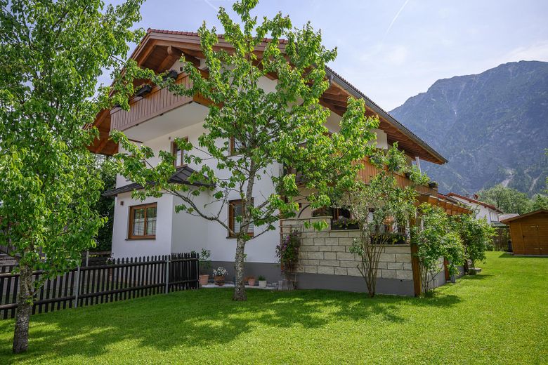 Sonniger Rasen mit Gartenhaus