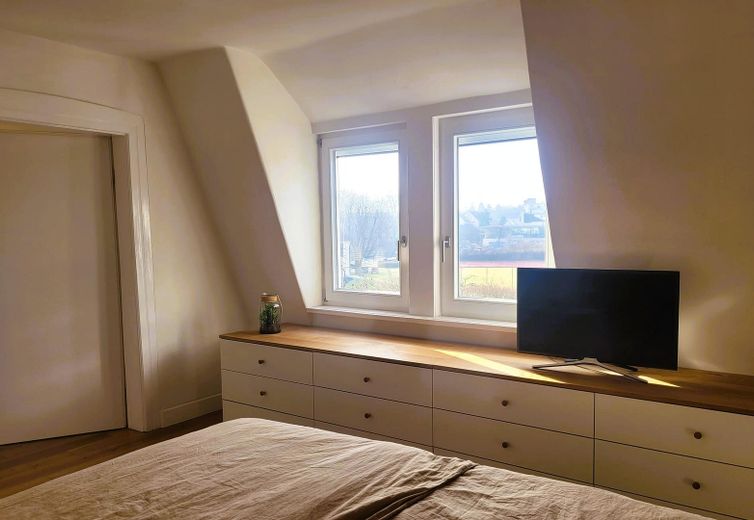 Bett mit Teckblick und TV