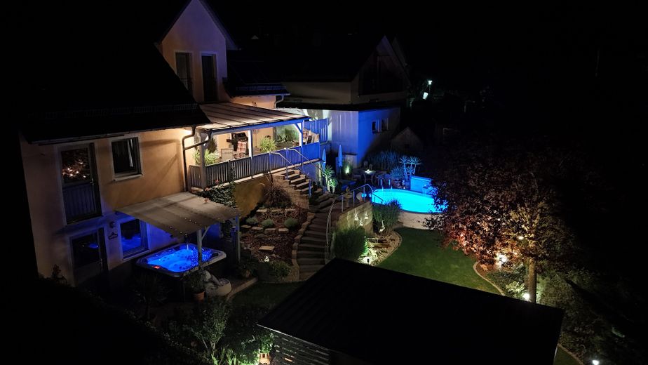 Orman kıyısında sakin bir konumda sıra dışı bir ev. Havuzlu, jakuzili ve uzak manzaralı eşsiz bir mülk. – Gartenansicht m. Abendbeleucht
