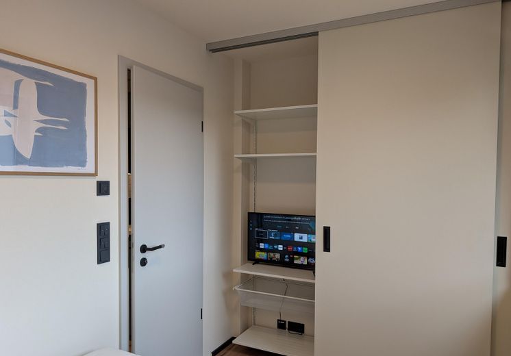 Voll möbliertes Apartment als Zweitwohnsitz auf Zeit im Zentrum von Greifswald – Schlafzimmer mit TV & Schrank