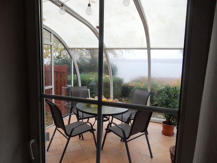 Idyllisches Haus am See mit Bootsanleger – Blick auf den Wintergarten