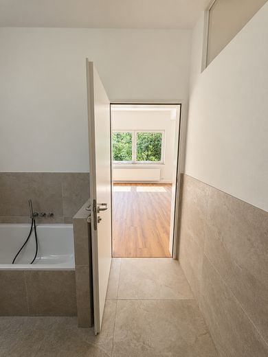 Spacious garden apartment with an exceptional living area, terrace, and direct views of greenery – Masterbadezimmer