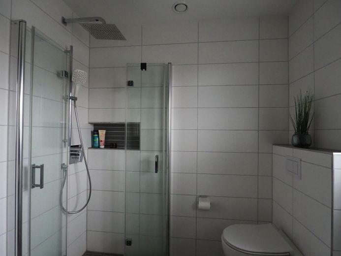 Dusche mit Glasfalttüren