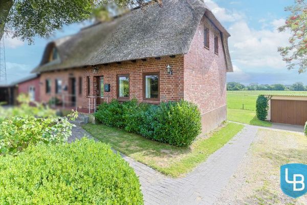 Porzione di casa bifamiliare con tetto in paglia e ampio terreno – grande potenziale per una personalizzazione individuale