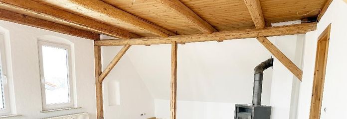 Wohnzimmer mit Kaminofen &amp; Holzbalkendecke - untere Wohnebene