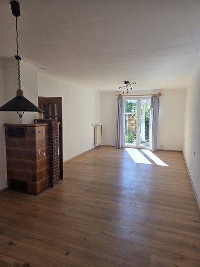 Doppelhaushälfte zentral, und doch im Grünen – Wohnzimmer mit Kachelofen