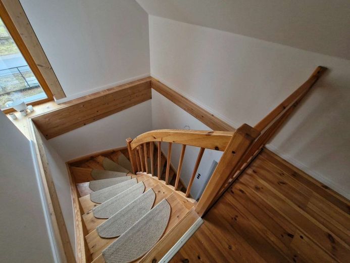 Hochwertige Baukunst &amp; nachhaltige Ausstattung - ein Zuhause mit Zukunft – massive Holztreppe zwischen EG und DG