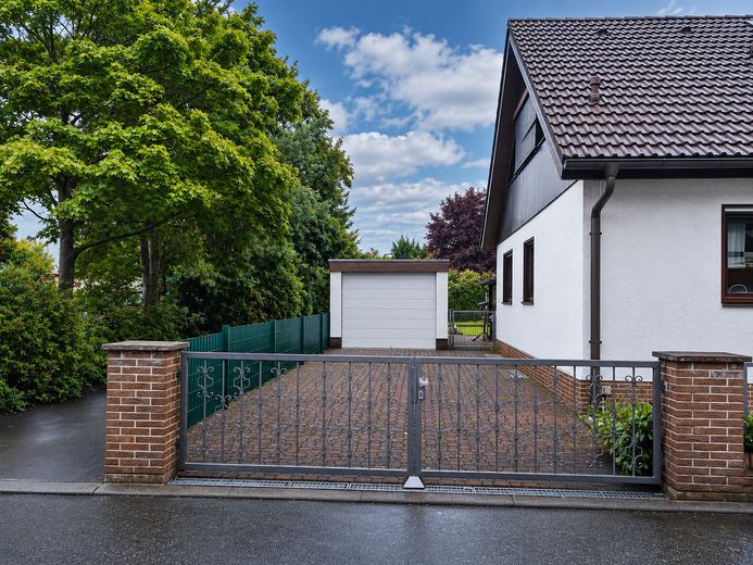 Ein Zuhause, das mehr kann. Stilvoll, großzügig und vielseitig. – Seitliche Ansicht mit Einfahrt