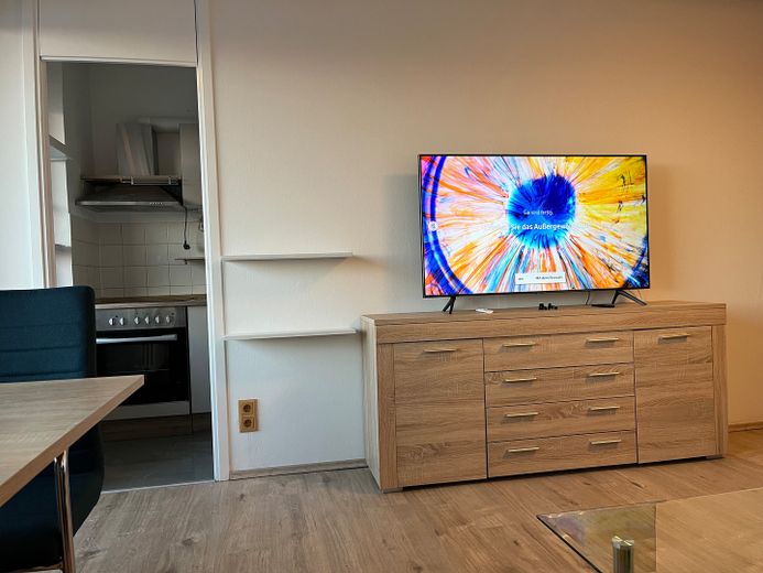Möbliertes Apartment im Münchner Süden mit Pool, Grünanlage und Fernblick – Wohnzimmer mit Eingang  Küche