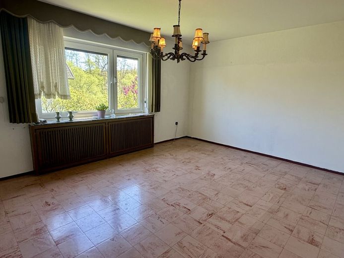 Viel Raum für Ideen: Zweifamilienhaus mit großem Garten, Garagen und Nebengebäude in Gohfeld – Wohnzimmer im EG
