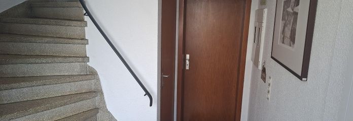 Bright three-room apartment, ground floor with large garden terrace – Treppenhaus mit Wohnungstür