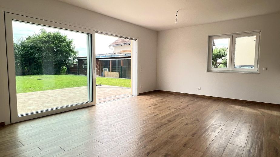 Ruhe mit Blick über Felder: Exklusives wohngesundes Plusenergie-Doppelhaus, S-Bahn fußläufig – Wohnzimmer mit Gartenblick