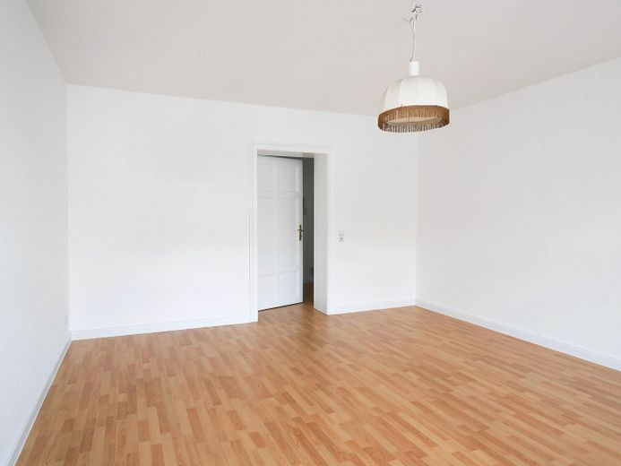 Bestandsvermietete 2-Zimmer-Altbauwohnung im denkmalgeschützten Gründerzeithaus – Wohnzimmer · Blick zum Flur