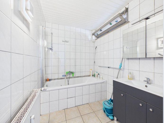 Komplett vermietetes Mehrfamilienhaus mit Gewerbe, 7 Garagen und Garten – Bad 1. OG
