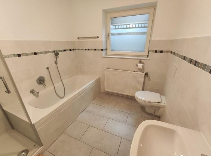 2 Zi. Souterrain Wohnung mit Terrasse und Garten (optional) – Bad mit Badewanne, Dusche und Waschmaschinenanschluss Bild 1