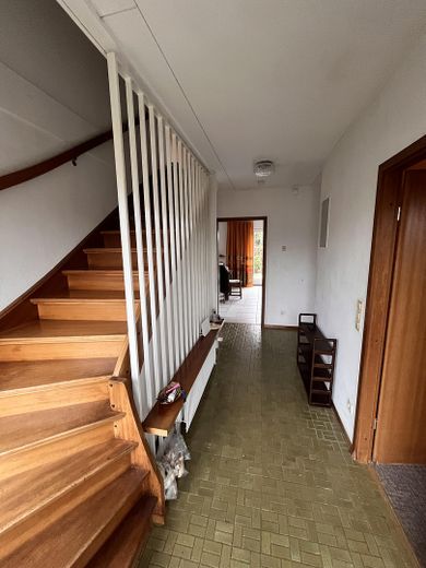 Flur und Holztreppe zum OG