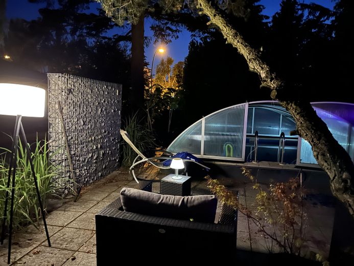 Haus im Bungalowstil als Fertigbau mit Pool, Nebengelass und großem Grundstück – Pool am Abend