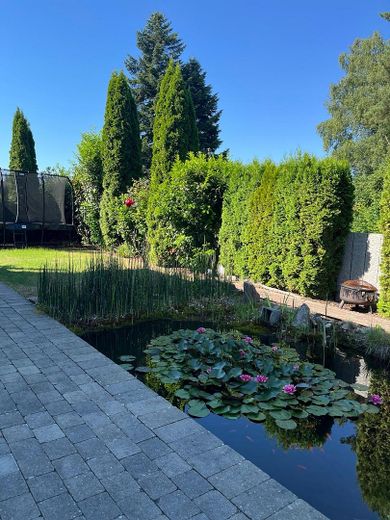 Modernes Einfamilienhaus mit Wintergarten, Doppelgarage und liebevoll angelegtem Garten in Schwendi – Garten mit Teich