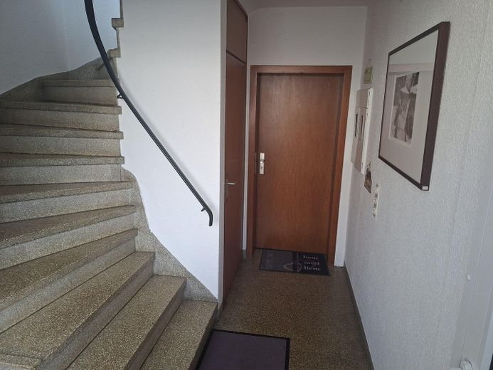 Helle Dreizimmerwohnung, Parterre mit großer Gartenterrasse – Treppenhaus mit Wohnungstür