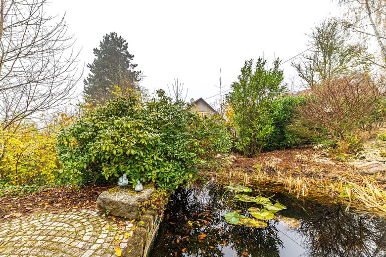 Zweifamilienhaus in Massivbau mit großem Garten in ruhiger Lage – Sitzplatz am Teich