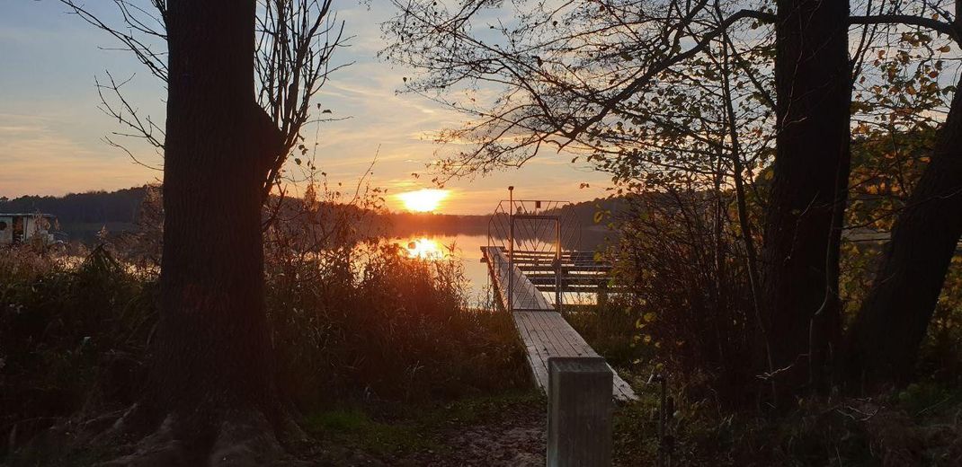 Ruhig, sicher und abseits von einer Stadt: Holzhaus Luxuslage im Wald eingebettet zwischen 3 Seen – Sonnenuntergang am Steg