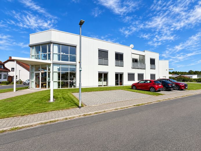 Immobile commerciale polivalente con showroom, capannone e unità abitativa a Heusenstamm – Seitenansicht mit Stellplätzen