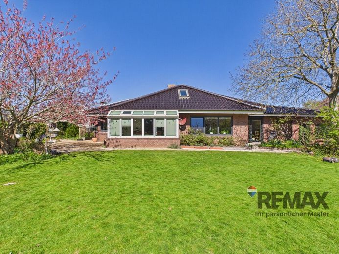 Modernisierter Bungalow mit kleiner Gewerbeeinheit in belebter Lage – Ansicht des Hauses aus dem Garten