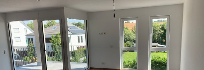 Premium 3-Zimmer-Wohnung mit 2 Balkonen, tollem Ausblick und EBK in Feldrandlage! A+ – Wohnzimmer Fensterfront