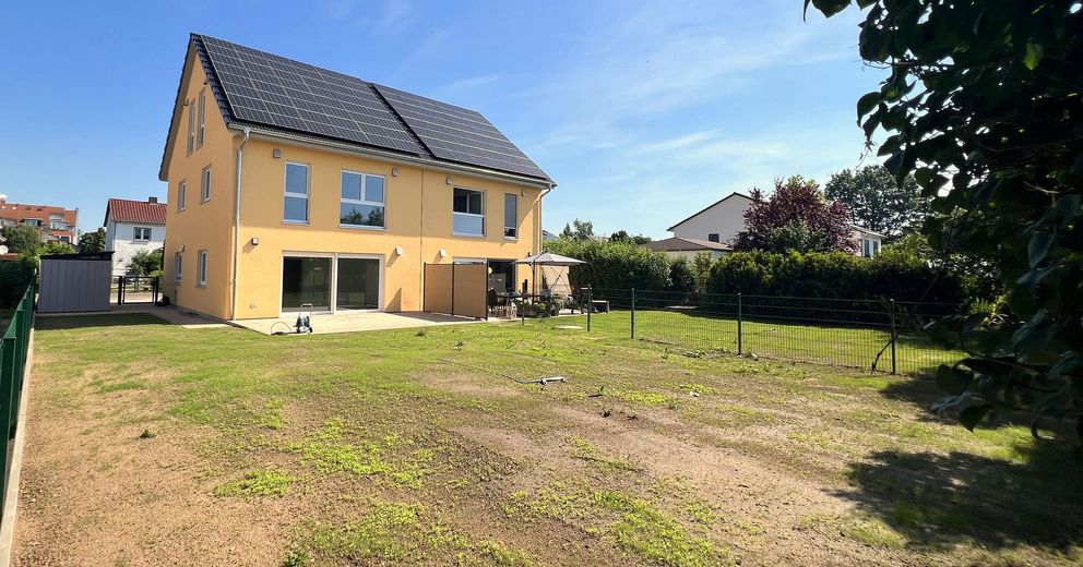 Ruhe mit Blick über Felder: Exklusives wohngesundes Plusenergie-Doppelhaus, S-Bahn fußläufig – Gartenansicht