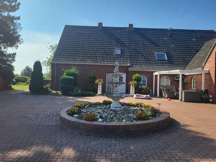 Exclusive detached house near Norddeich with pool, sauna, horse keeping – Ansicht Haus mit Brunnen