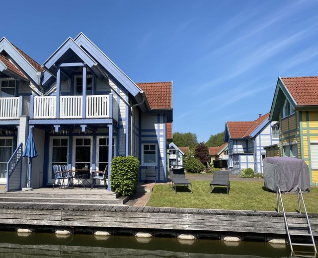 Ferienhaus mit eigenem Bootssteg im Hafendorf Rheinsberg – Ansicht vom Wasser