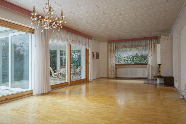 Platz für Familie, Ideen und neue Lebensabschnitte – Das Wohnzimmer mit Kamin und dem Wintergarten